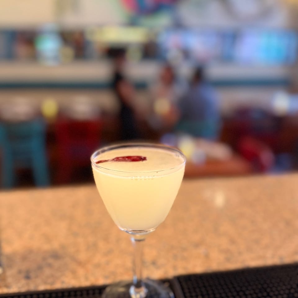 A pale cocktail in a stemmed glass at the bar